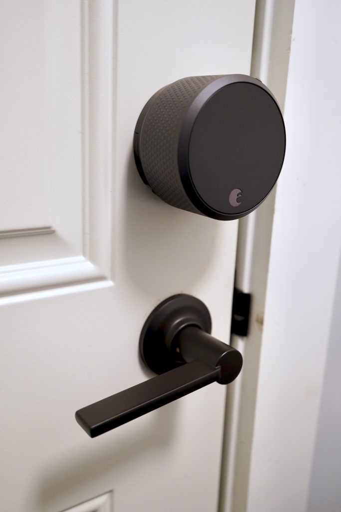 Circular August smart lock on the inside of the door.