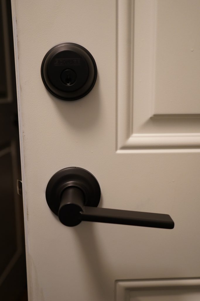 Interior lock hardware above a black door handle.