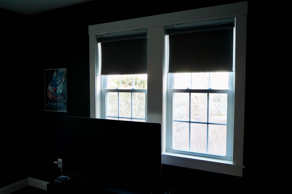 Motorized roller shades covering two windows.