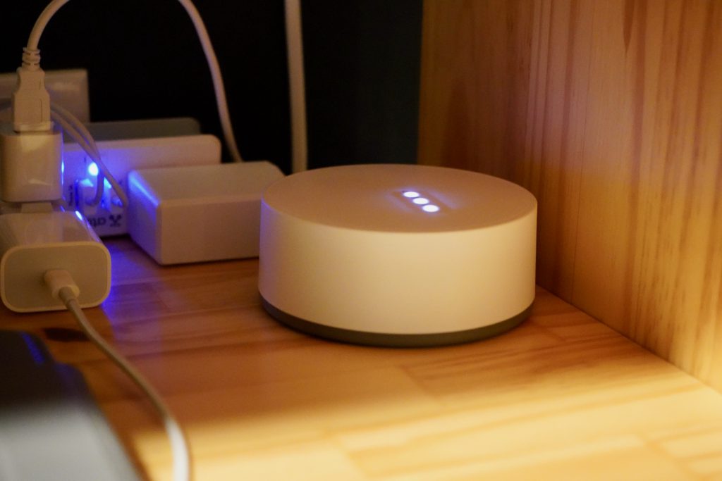 Round IKEA smart-home hub on a wooden shelf.